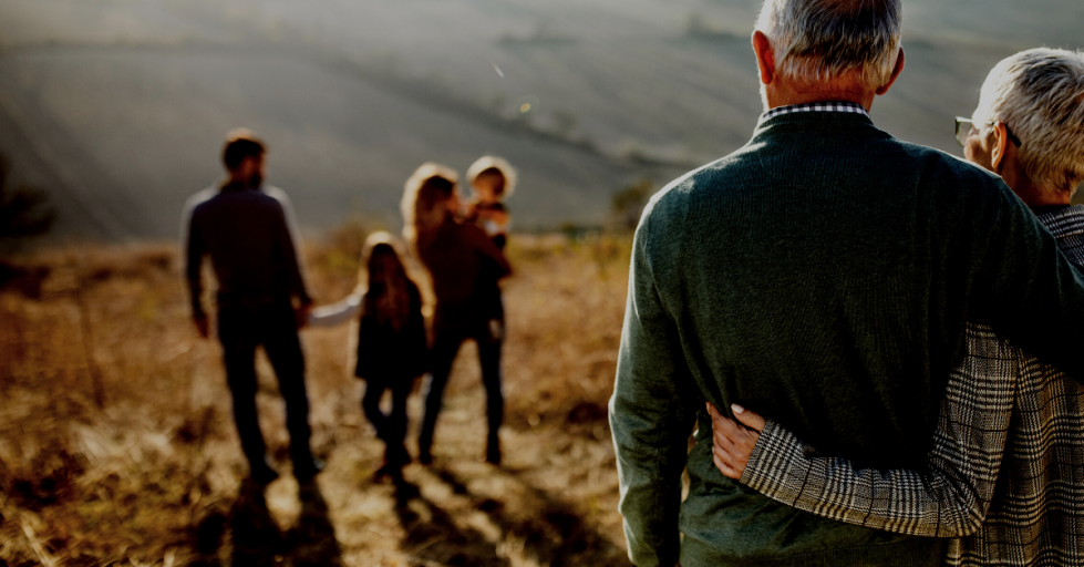 Older couple watch their children and grandchildren walking away